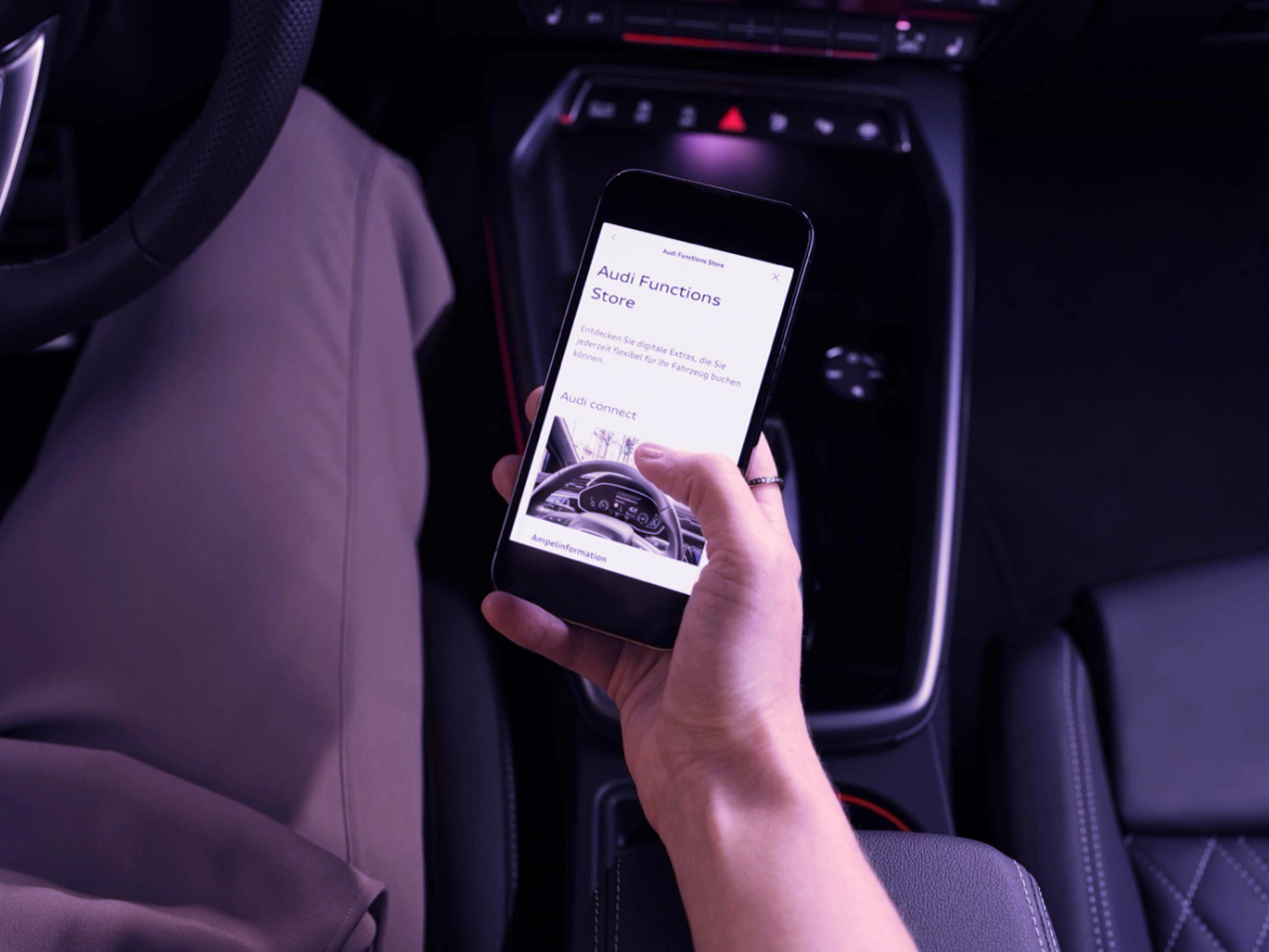 Detail of a hand holding a smartphone inside a car. 